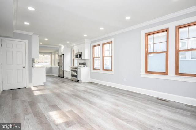 unfurnished living room with ornamental molding and light hardwood / wood-style floors