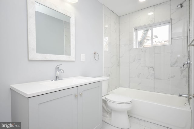 full bathroom featuring tiled shower / bath combo, vanity, and toilet