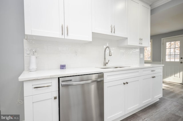 kitchen featuring sink, white cabinetry, stainless steel dishwasher, hardwood / wood-style flooring, and light stone countertops