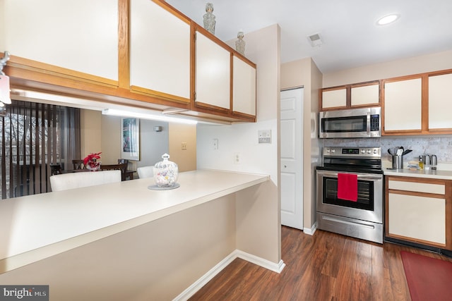 kitchen featuring white cabinetry, appliances with stainless steel finishes, dark hardwood / wood-style floors, and backsplash