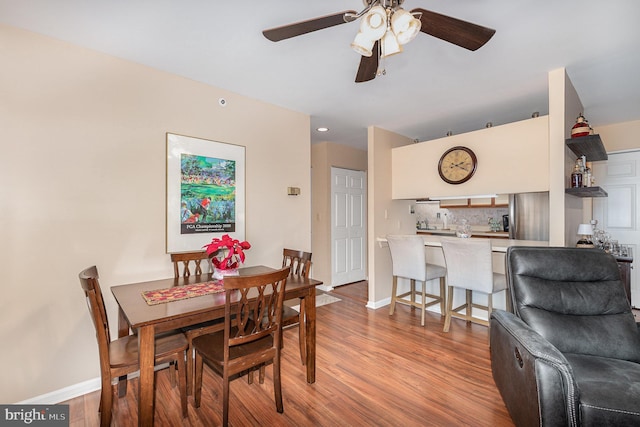 dining area with light hardwood / wood-style floors and ceiling fan