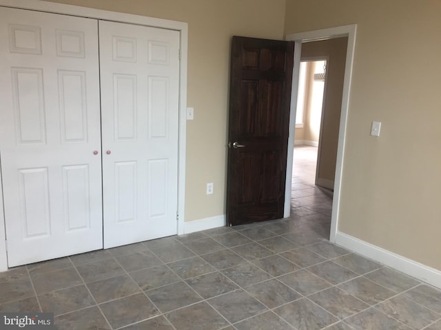 unfurnished bedroom with tile patterned floors and a closet