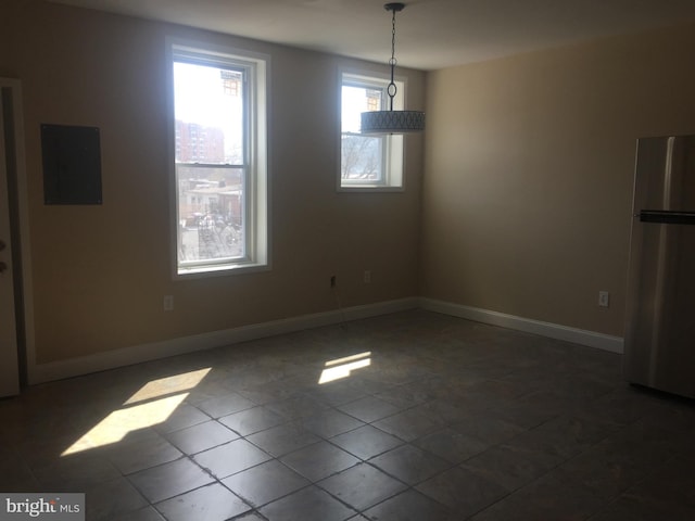 unfurnished dining area featuring electric panel and dark tile patterned flooring