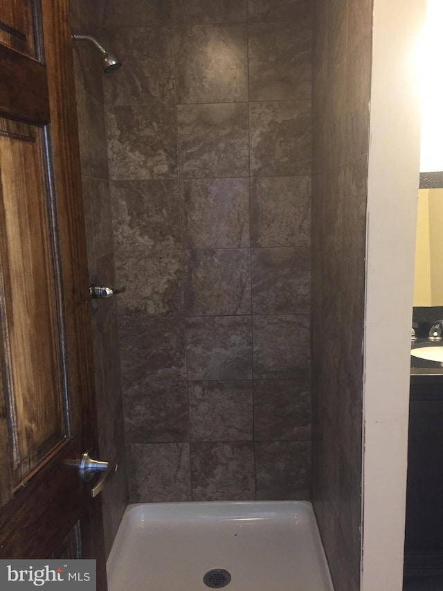 bathroom with sink and a tile shower