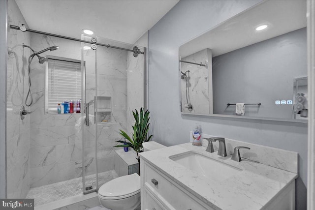 bathroom featuring vanity, toilet, and a shower with shower door