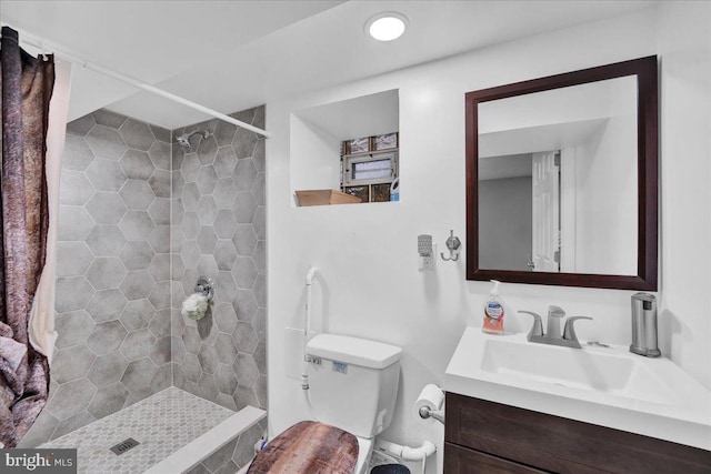 bathroom with vanity, toilet, and a tile shower