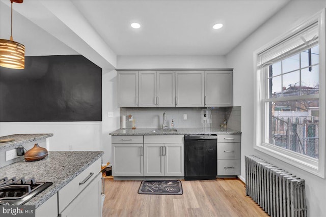 kitchen with pendant lighting, sink, dishwasher, radiator heating unit, and stainless steel gas stovetop