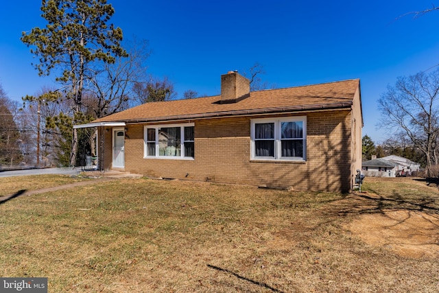 view of front of property featuring brick siding, crawl space, a chimney, and a front yard