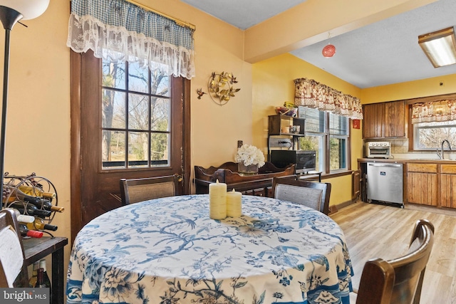 dining room with a wealth of natural light, light wood-style flooring, and a toaster