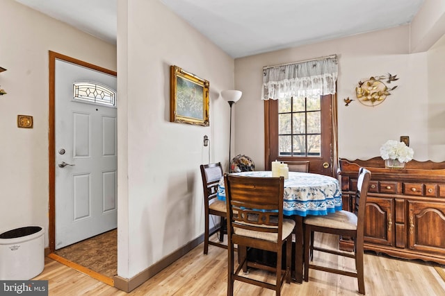 dining room with baseboards and light wood-type flooring