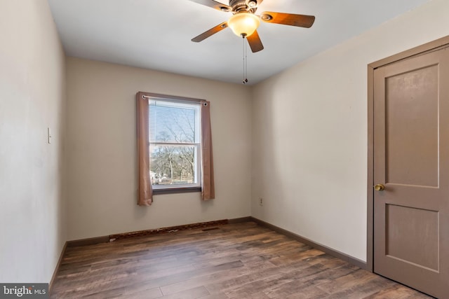 unfurnished room with baseboards, wood finished floors, and a ceiling fan