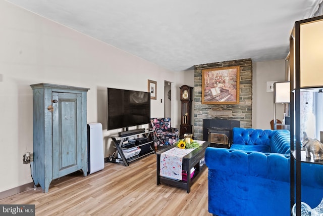 living room with a wood stove and light wood-style floors