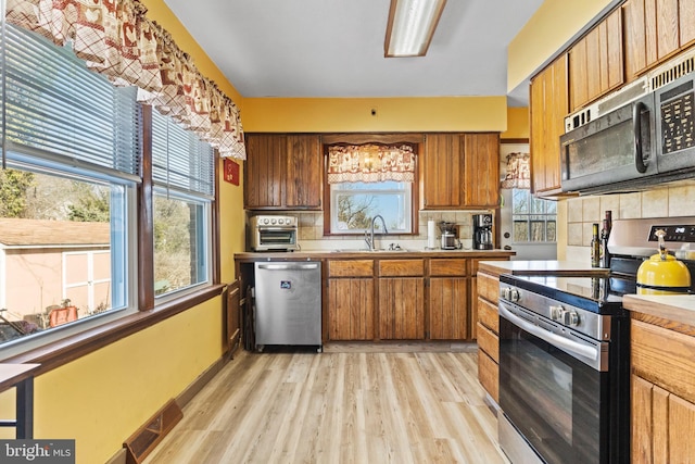 kitchen with visible vents, backsplash, stainless steel appliances, and a sink