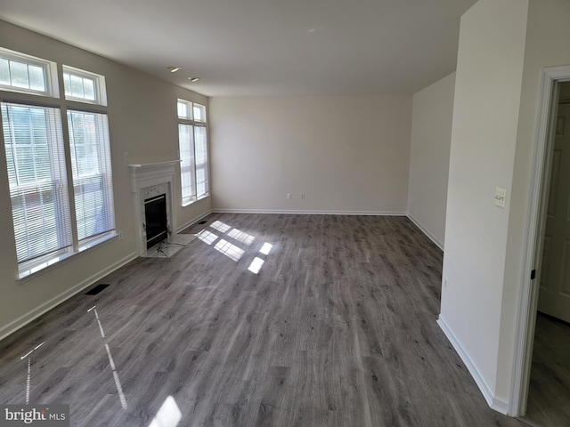 unfurnished living room featuring dark hardwood / wood-style floors and a premium fireplace