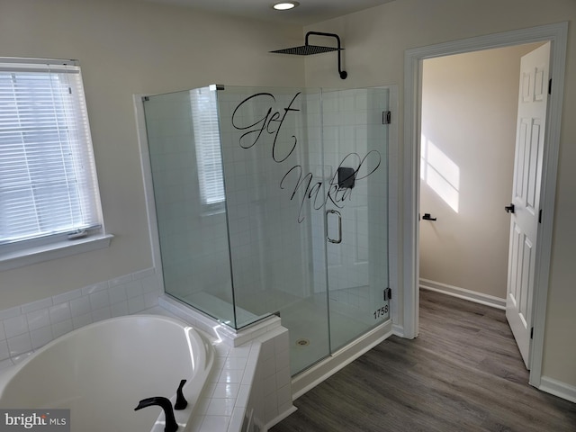 bathroom with hardwood / wood-style floors, plus walk in shower, and a healthy amount of sunlight