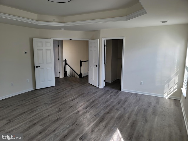 unfurnished room with wood-type flooring and a raised ceiling