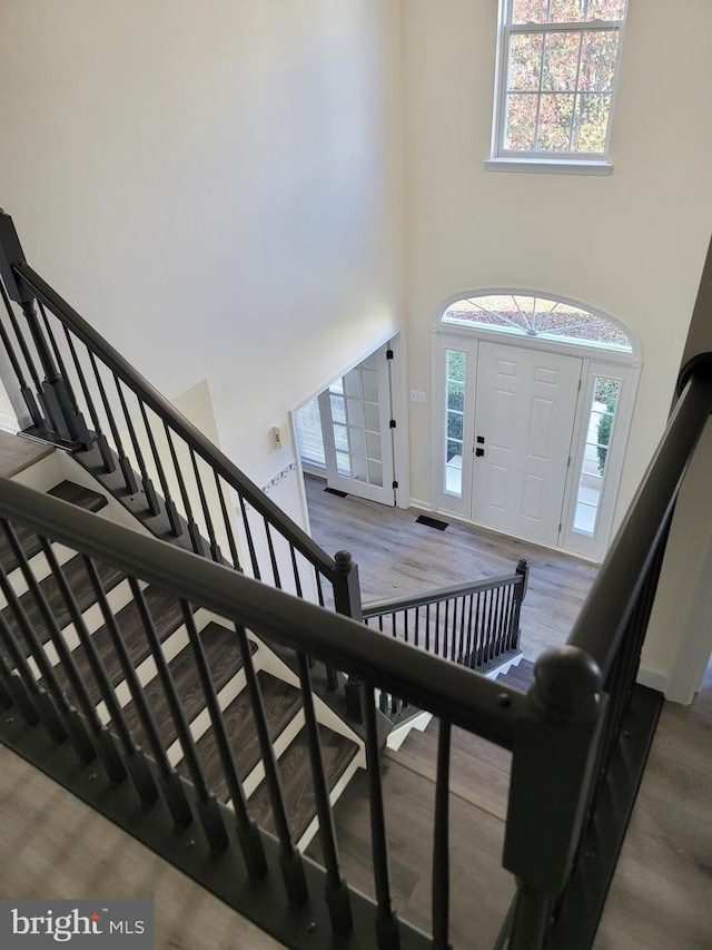 entryway featuring a towering ceiling and light wood-type flooring