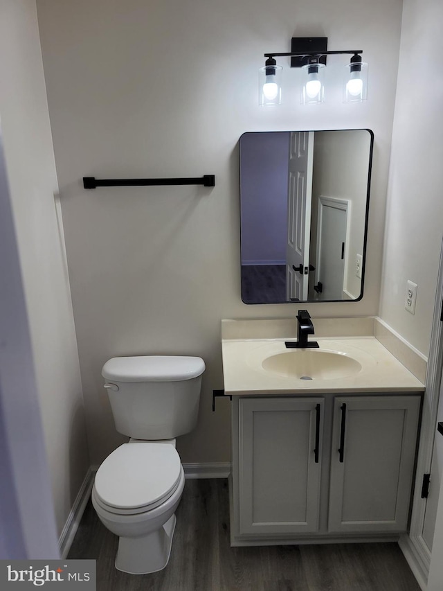 bathroom with hardwood / wood-style flooring, vanity, and toilet