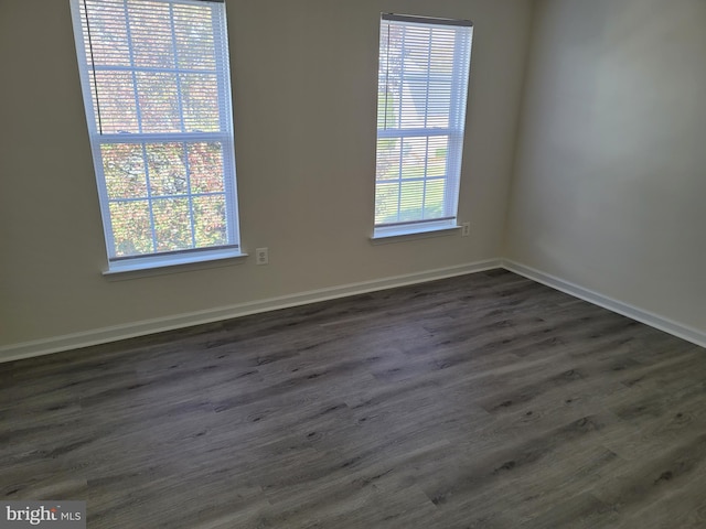 unfurnished room with plenty of natural light and dark hardwood / wood-style floors