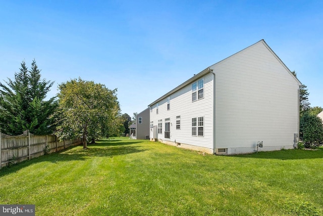 rear view of property featuring a lawn