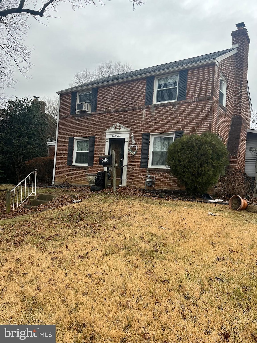 view of front of home featuring cooling unit and a front lawn