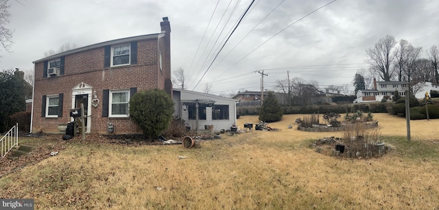 view of front of house with cooling unit and a front lawn