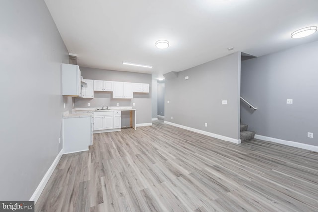 kitchen featuring white cabinetry, sink, and light hardwood / wood-style floors