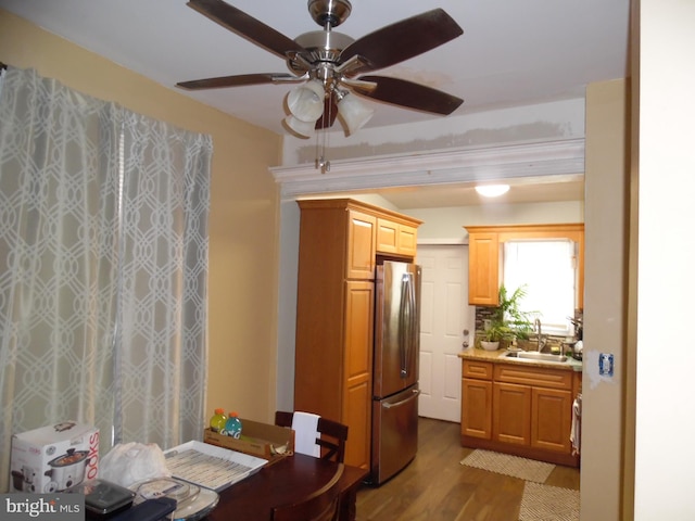 kitchen featuring wood-type flooring, stainless steel fridge, and sink