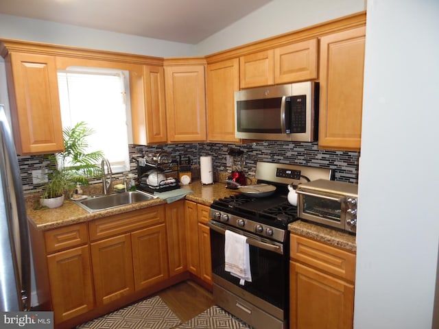 kitchen featuring appliances with stainless steel finishes, sink, and decorative backsplash