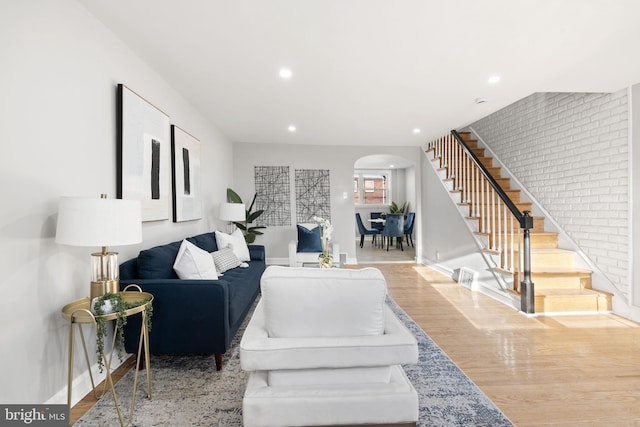 living room featuring brick wall and hardwood / wood-style floors