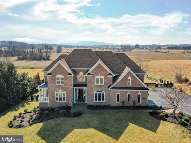 craftsman-style house with a rural view, a mountain view, and a front yard