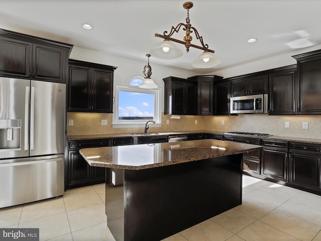 kitchen featuring pendant lighting, appliances with stainless steel finishes, a kitchen island, and light tile patterned floors