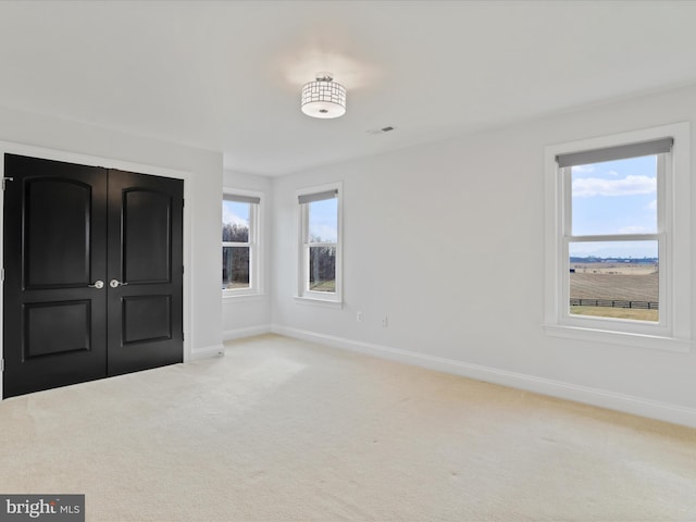 unfurnished bedroom featuring light carpet and a closet