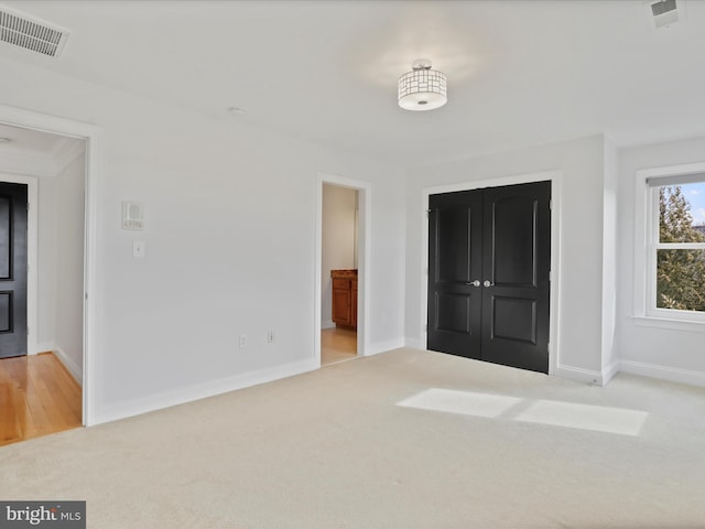 unfurnished bedroom featuring light carpet