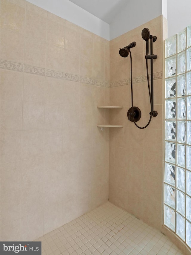 bathroom with a tile shower and vaulted ceiling