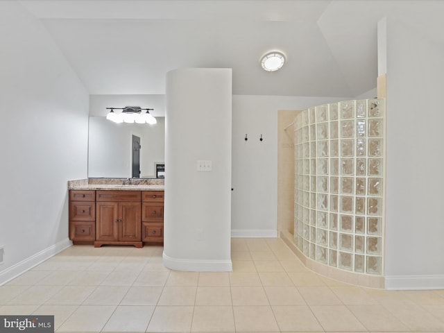 bathroom with walk in shower, vanity, and tile patterned flooring