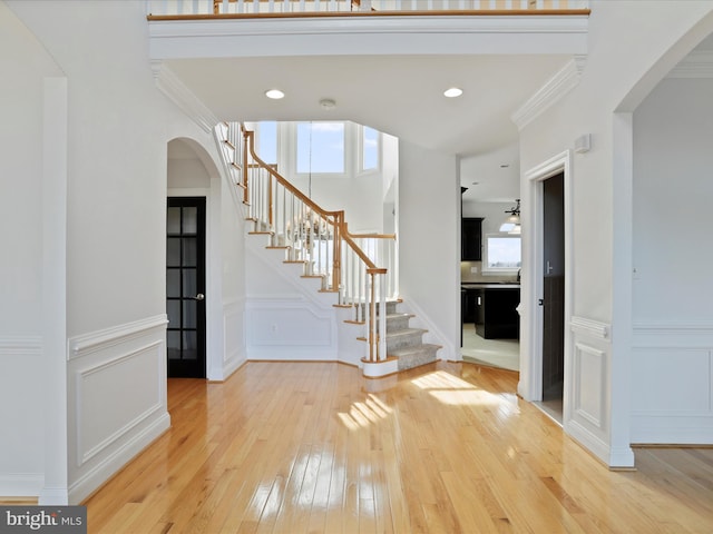 foyer entrance with hardwood / wood-style flooring and ornamental molding