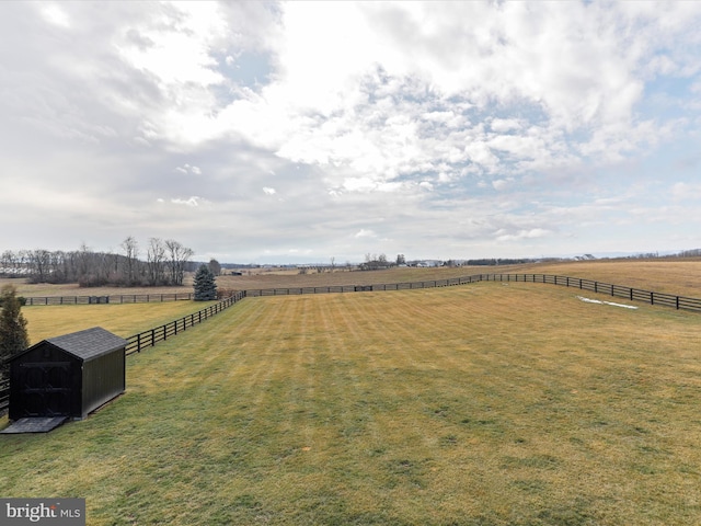 view of yard featuring a rural view and a storage unit