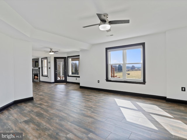 unfurnished living room with ceiling fan and dark hardwood / wood-style flooring