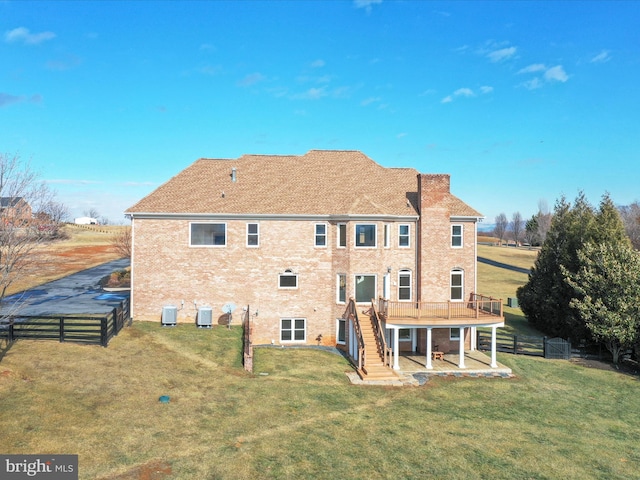 back of property featuring a deck and a lawn