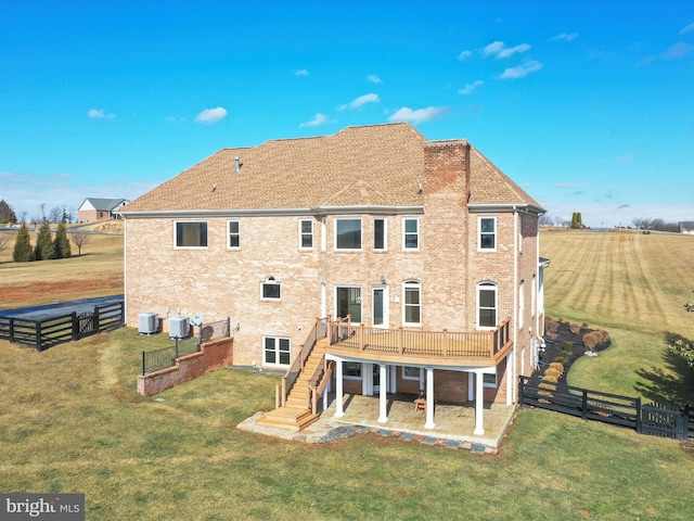 back of property with central AC unit, a patio, a deck, and a lawn