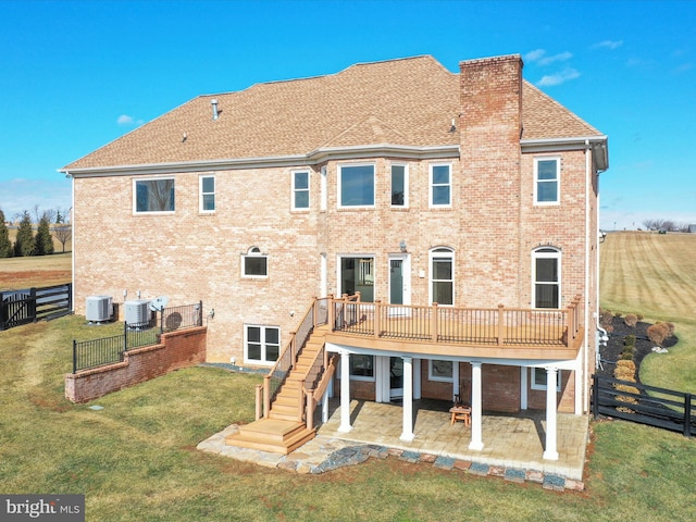 back of house featuring a wooden deck, a yard, cooling unit, and a patio area