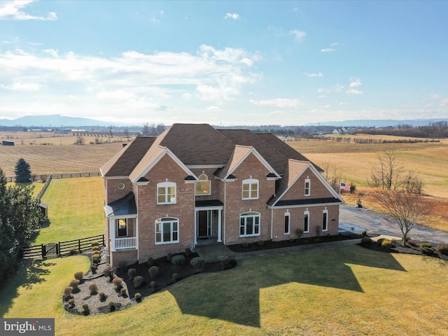 craftsman-style home with a rural view, a mountain view, and a front lawn