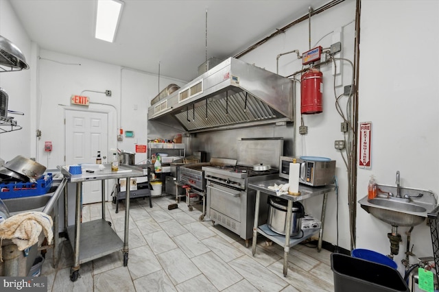 kitchen featuring island exhaust hood, appliances with stainless steel finishes, and sink