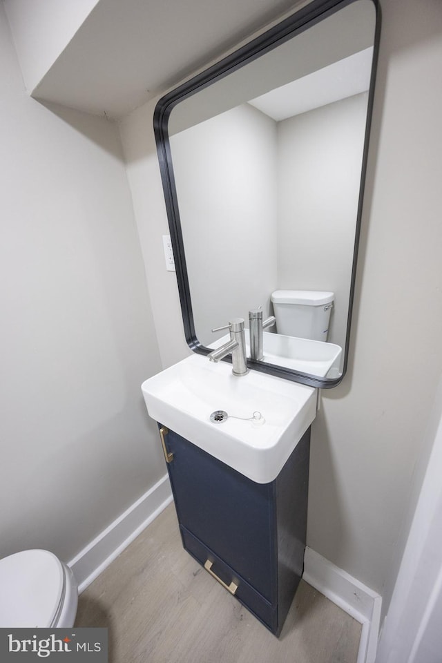 bathroom featuring vanity, wood-type flooring, and toilet