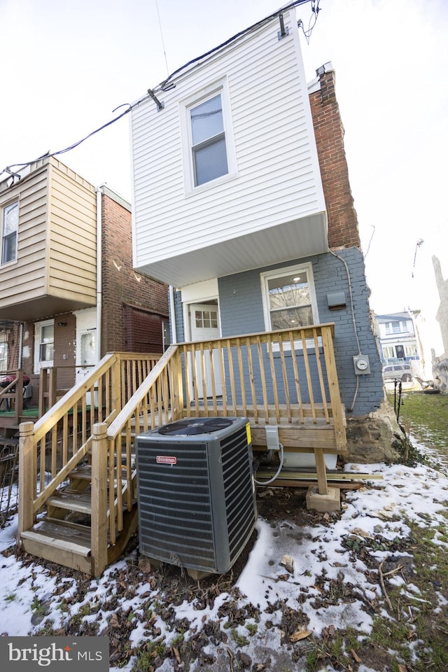 snow covered property featuring central air condition unit