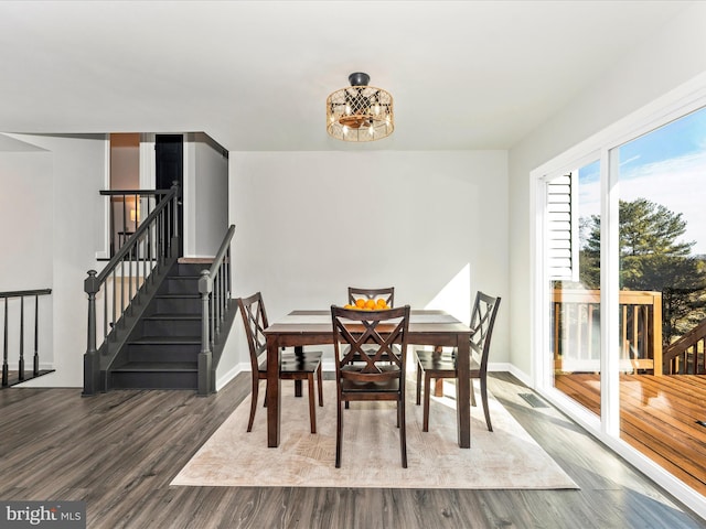 dining area with hardwood / wood-style floors and an inviting chandelier