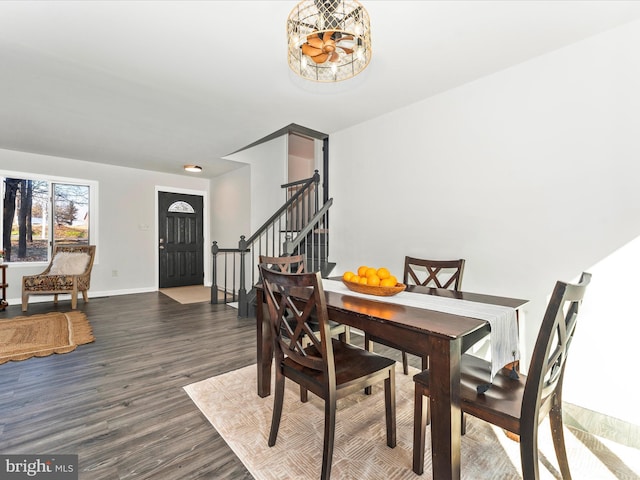 dining space featuring dark wood-type flooring and an inviting chandelier