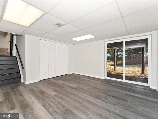 interior space featuring a paneled ceiling and dark hardwood / wood-style flooring