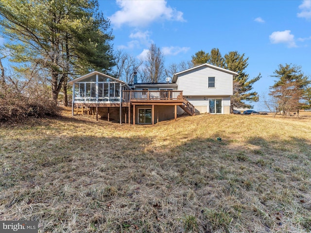 back of property featuring a sunroom, a deck, and a lawn